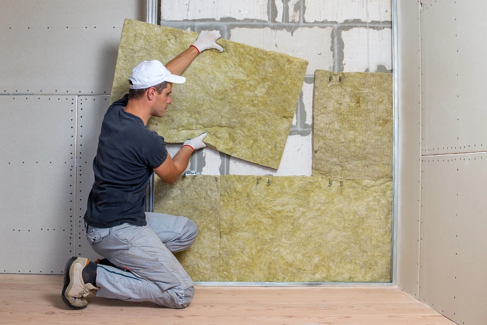 Chantier de construction en intérieur avec ouvrier manipulant des matériaux